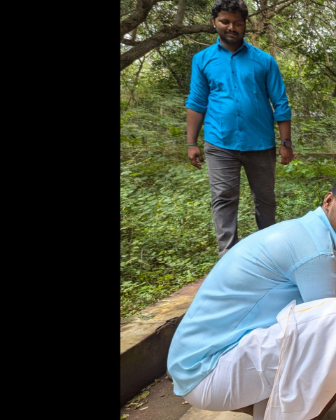 Students at AIAT create colorful rangoli designs on the ground outside a campus building surrounded by greenery. They are smiling and working together, dressed in traditional attire. The left side of the image has the AIAT logo and text that reads: 'YOU + US = YOUTH EMPOWERED. With your donations, we can help our students find their calling.